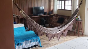 A room with a hammock, a bed, a desk with a computer, and a window with curtains. - Penthouse with pool, barbecue, and bathtub: Jeanne's Country House (Rio de Janeiro)