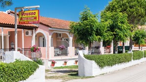 Un edifici rosa amb un cartell que diu 'Roussa', que indica que és un immoble de lloguer.