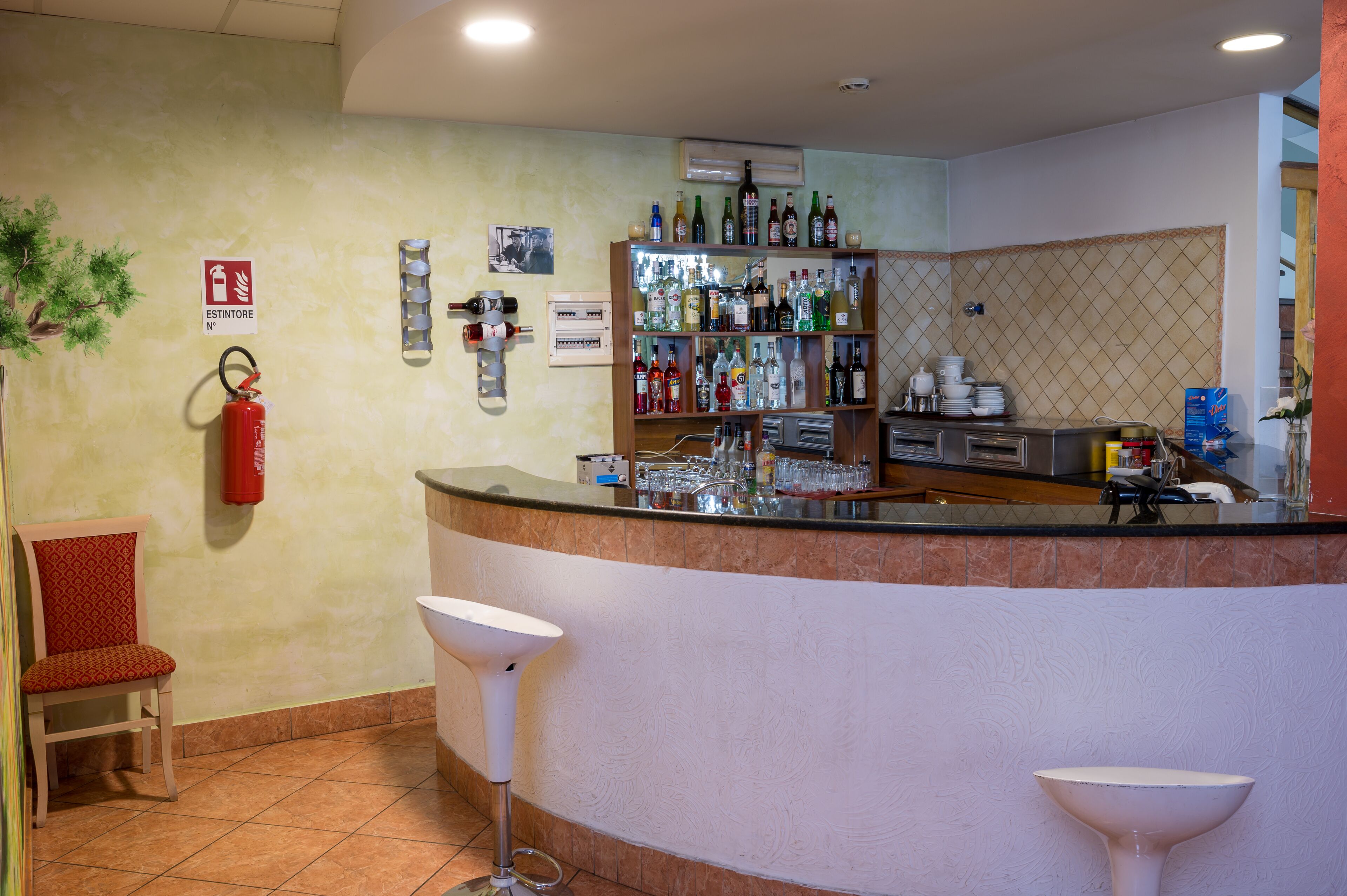 Zona de bar con mostrador, taburetes y extintor.