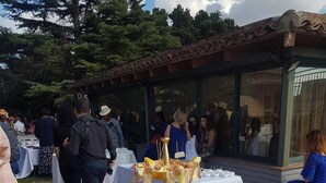 Una mesa redonda con mantel blanco y un adorno central.