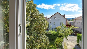 Un quartiere residenziale con una casa bianca, un giardino e un cielo azzurro intenso.