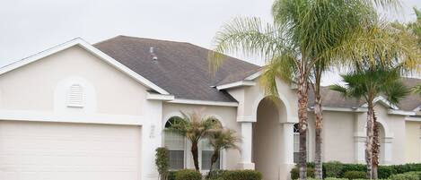 A single-story house with a garage, a front porch, and a mailbox.