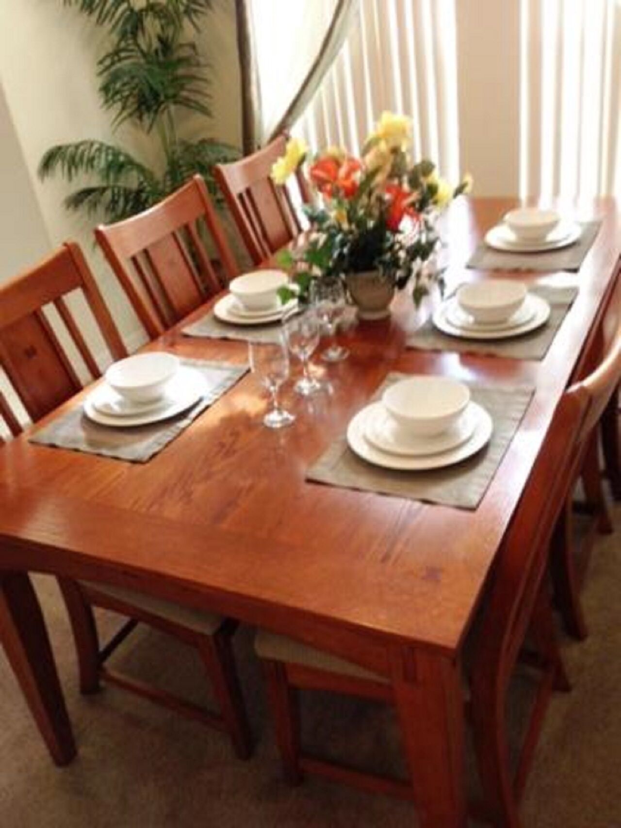 A dining table set with plates, glasses, and a centerpiece.