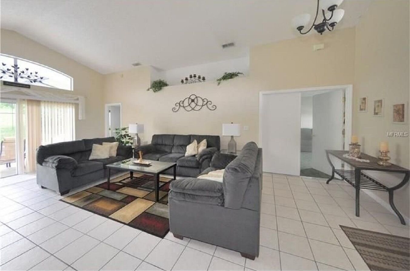 A living room with two grey sofas, a coffee table, and a patterned rug.
