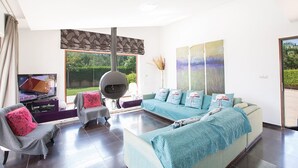 Una sala de estar moderna con un sofá grande, un televisor y una mesa de comedor.