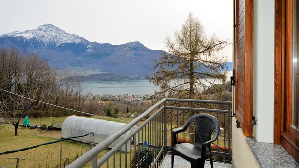 Een balkon met uitzicht op bergen en een meer.