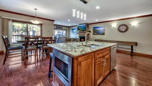 A spacious kitchen with a large island, wooden cabinetry, and a built-in microwave. - Tahoe Woods #602 Walk to Gondola, Lake, Casinos (South Lake Tahoe)