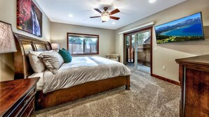 A bedroom with a large bed, a ceiling fan, a sliding glass door leading to a balcony, and a large TV on the wall. - Tahoe Woods #602 Walk to Gondola, Lake, Casinos (South Lake Tahoe)