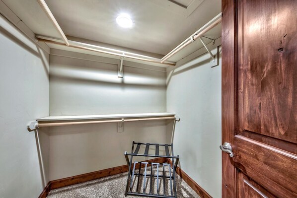 A small, narrow hallway with a wooden door on the right, a metal rack with a towel, and a ceiling light.