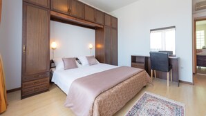 A bedroom with a large bed, wooden wardrobe, desk, and chair. - PENDO 3 apartment with 4 bedrooms, sea view, close to beaches and Dubrovnik (Mlini)