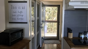 A modern kitchen with a microwave, a large window, and a door leading to a balcony. - PERFECT VIEW!!! Waterfront, Marina and 2 Pools! (Fort Walton Beach)