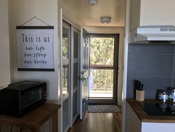 A kitchen with a microwave, a door with a glass panel, and a sign on the wall. - PERFECT VIEW!!! Waterfront, Marina and 2 Pools! (Fort Walton Beach)