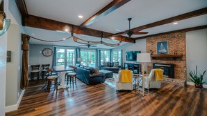A spacious living room with a fireplace, a dining area, and a large window. - 2-Bedroom, Dog Friendly Home sleeps 6 on the Tennessee River/Chickamauga Lake (Decatur)
