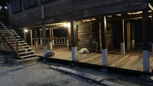 A wooden house with a covered porch and a staircase leading to the entrance. - Belize Blue Hole Tropical Cabin for Scuba divers! (Lighthouse Reef)