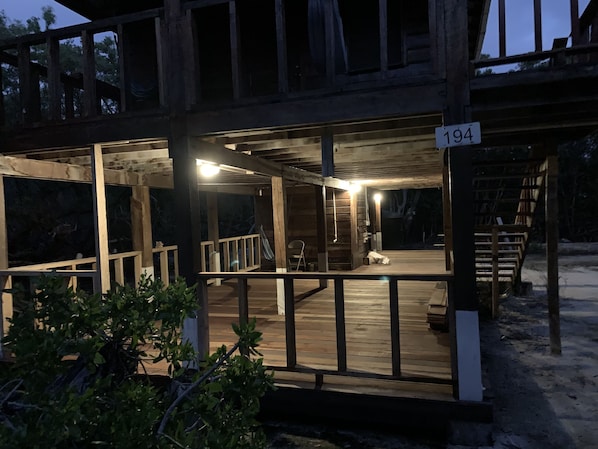 A wooden deck with a railing, a hammock, and a sign with the number 194.