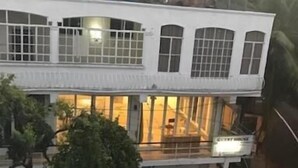 Un immeuble de deux étages doté de grandes fenêtres et d’un balcon.