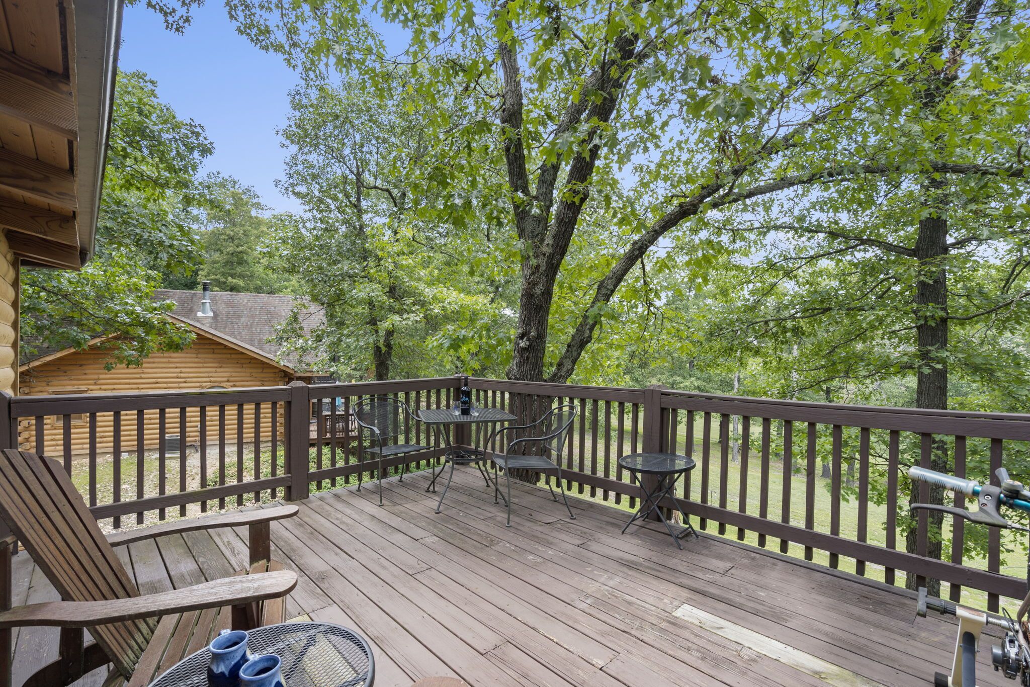 A wooden deck with outdoor furniture, a small table, and chairs.