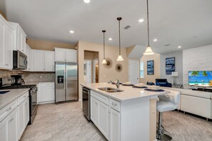 Enjoy cooking in this well-equipped kitchen with a central island, sink, and ample counter space.