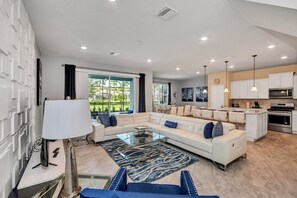 Enjoy a spacious living area with a large sofa, glass coffee table, and contemporary lamp.