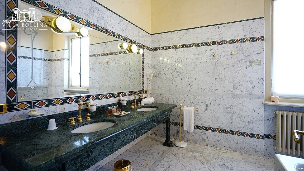 Un baño con dos lavamanos, un espejo grande y un radiador.