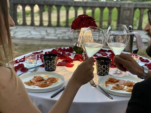 Una mesa dispuesta con platos de comida, copas de vino y velas decorativas.