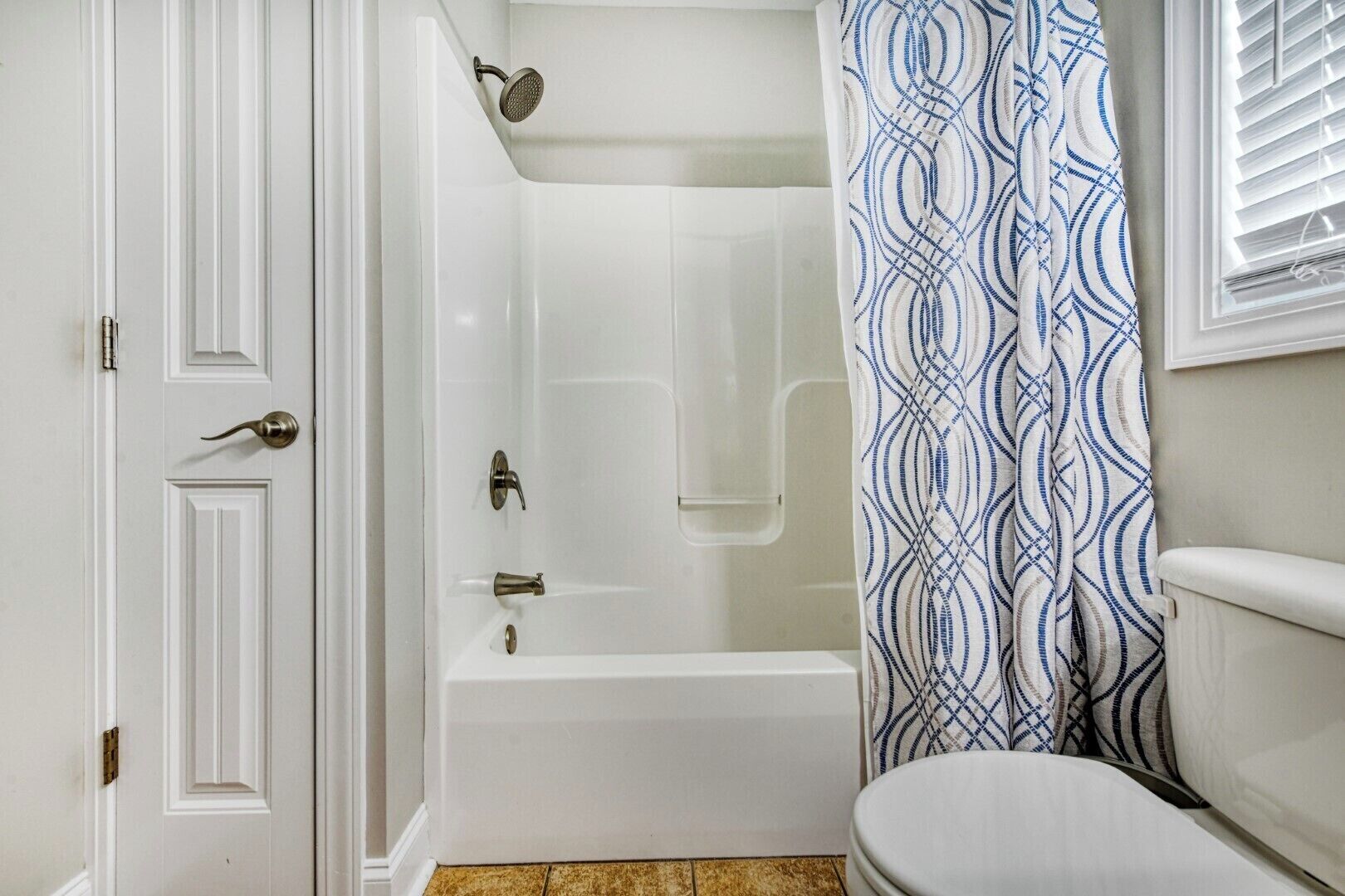 Un baño con una bañera blanca, ducha y retrete.