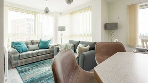 A living room with a sofa, armchairs, a coffee table, and a TV. - Tally Ho -Parking and Wi-Fi included (Poole)