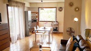 Una sala de estar con sofá, una mesa de centro y un comedor con mesa y sillas.