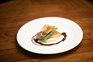Un plato blanco con comida sobre una mesa de madera.