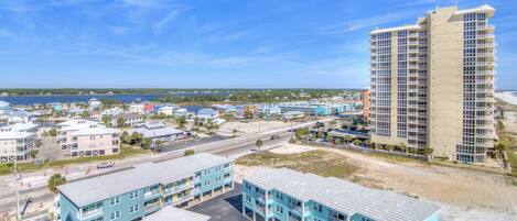 A coastal hotel with multiple buildings, including a tall hotel and several smaller structures.