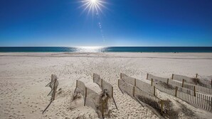 Une plage avec un ciel dégagé et un soleil éclatant.