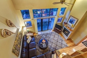 A spacious living room with a large window, a fireplace, and a cozy seating area.
