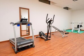 A gym with a treadmill, elliptical, and weight bench. - Celine Home Al Malqa (Riyadh)