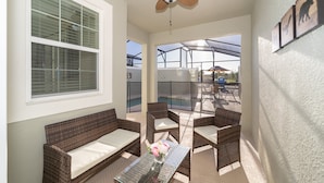 A balcony with wicker furniture, a ceiling fan, and a glass railing. - (FA4830) Storey Lake Home 4/3 Private Pool & Free Waterpark (Kissimmee)