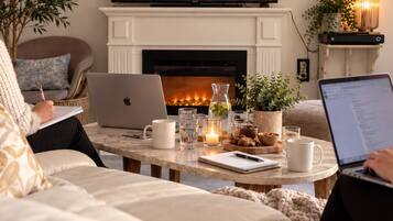 A cozy living room with a fireplace, a television, and a comfortable seating area.