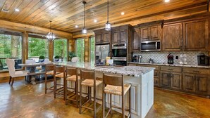 Una cocina amplia con armarios de madera, encimera de granito y una isla grande con taburetes de bar.