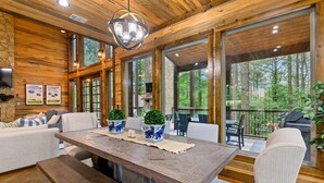 Un interior de madera con una mesa de comedor, sillas y una chimenea de piedra.