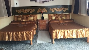 A double bed room with a headboard, a bedside table, and a decorative wall piece. - Hostal Bola 8 (Remedios)