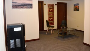 A hotel room with a bed, a small table, a chair, a television, and a carpeted floor. - Los Angeles Stay Inn (Quito)