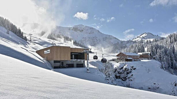 A snow-covered mountain resort with wooden buildings, ski lifts, and a clear sky. - Vacation cottage Greber, Austria (Mellau)
