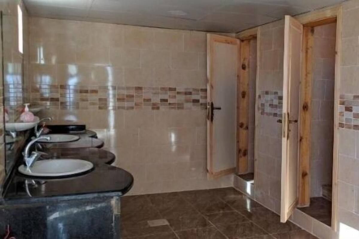 Ein Badezimmer mit zwei Waschbecken, einer Dusche und Holztüren.