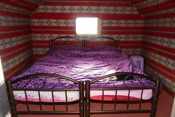 Una habitación con cama, ventana y paredes decoradas.