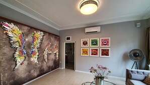 A spacious lobby with a modern design, featuring a large wall mural, a glass coffee table, and a sofa. - artHotel Bremen (Bremen)