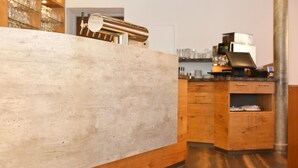 A bar area with a wooden counter, a beer tap, and a coffee machine. - Gasthof Adler (Hettingen)