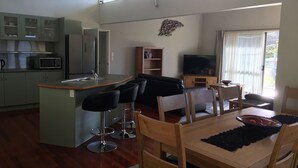 A compact living space with a kitchen, dining area, and a living room. - Bay of Islands Gateway Motel (Paihia)