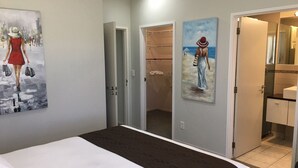 A hotel room with a bed, a closet, and two paintings on the walls. - Bay of Islands Gateway Motel (Paihia)
