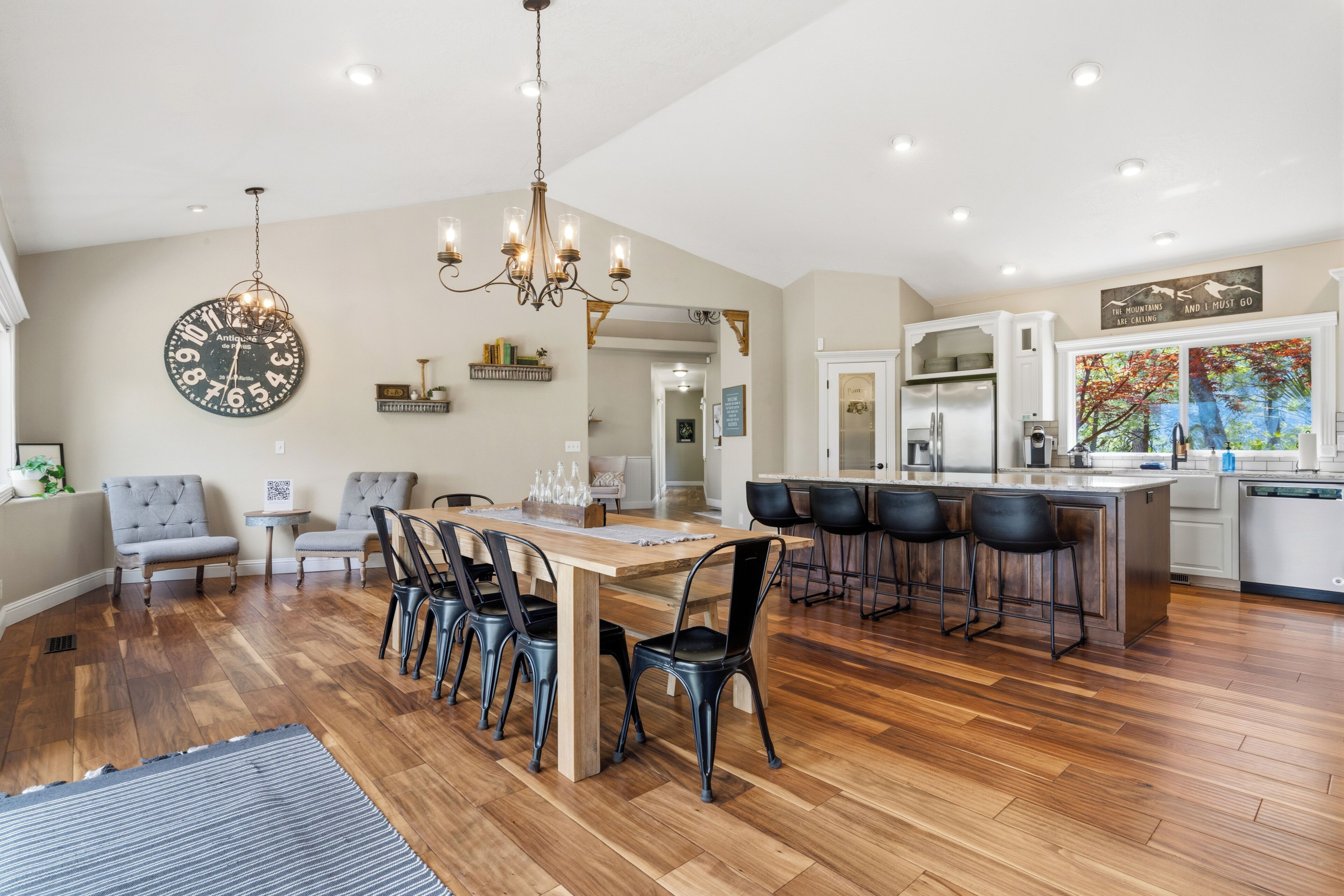 A spacious kitchen with a dining area, wooden flooring, and modern appliances.