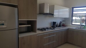Een moderne keuken met een inbouwoven, een gasfornuis en een roestvrijstalen afzuigkap.