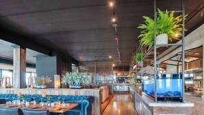 A modern restaurant with a bar area, seating, and decorative plants. - Oesterdam Resort by Interhome (Tholen)