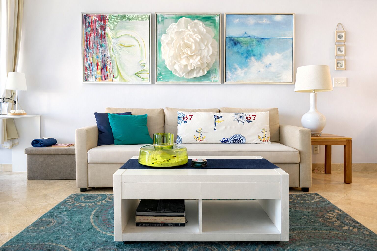 A living room with a sofa, a coffee table, a rug, and wall art.